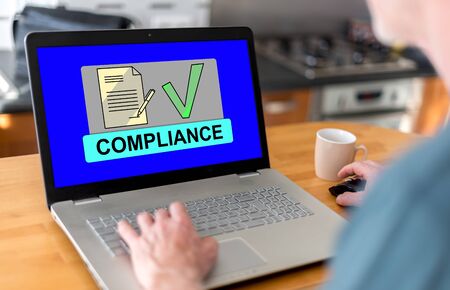 Man using a laptop with compliance concept on the screenの写真素材