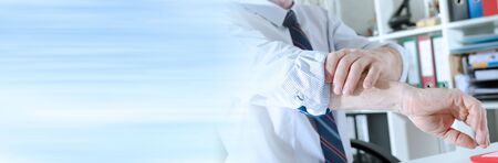 Businessman rolling up his sleeve at office; panoramic bannerの写真素材