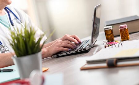 Female doctor using laptop in medical office