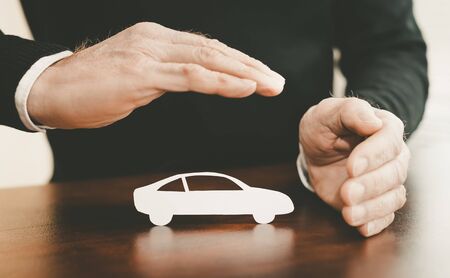 Insurer protecting a car with his handsの写真素材