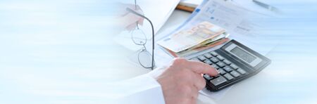 Woman accountant calculating taxes; panoramic bannerの写真素材