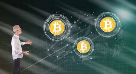 Businessman showing a bitcoin currency concept on a wall screen