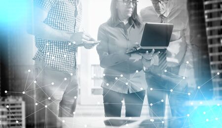 Business people in meeting working on laptop in office, light rays effect; multiple exposure