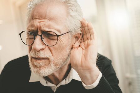 Portrait of senior man having hearing problemsの写真素材