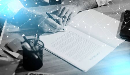 Businessman signing a document in office (lorem ipsum text used; light effect