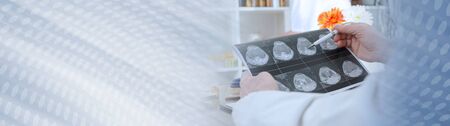 Doctor analyzing a mri scan in medical office; panoramic bannerの写真素材