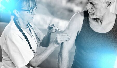 Female doctor injecting vaccine to senior man; multiple exposureの写真素材