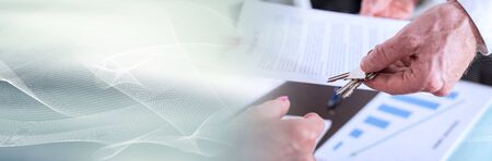 Realtor giving house keys to his client after signing the contract; panoramic banner