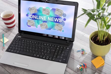 Laptop on a desk with online news concept on the screenの写真素材