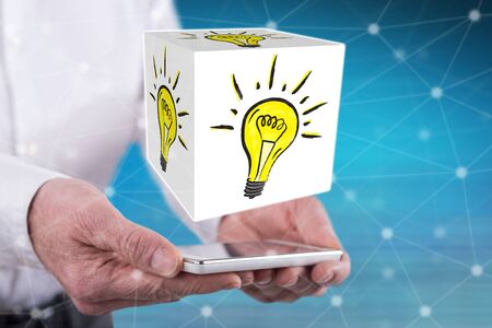 Innovation concept above a smartphone held by handsの写真素材