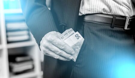 Businessman removing euro banknotes from his pocket; multiple exposure