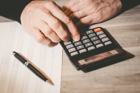 Male hand using a calculator, closeupの写真素材