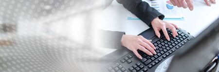 Workteam in office working on a computer; panoramic banner