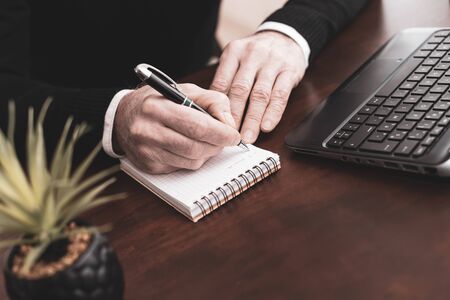 Male hands taking notes on notebookの写真素材