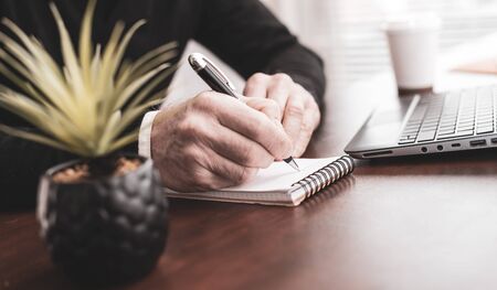 Male hands taking notes on notebookの写真素材