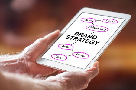 Man holding a tablet showing brand strategy conceptの写真素材
