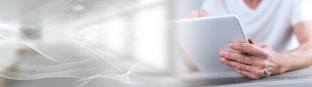 Man sitting using a tablet; panoramic bannerの写真素材