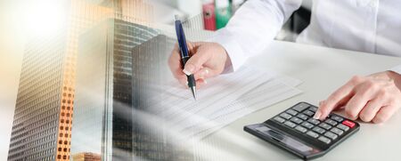 Woman accountant working on financial results; multiple exposureの写真素材
