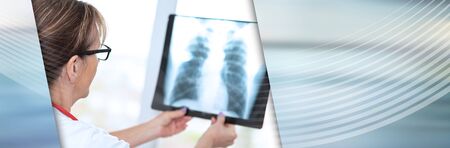 Female doctor looking at x-ray in clinic; panoramic bannerの写真素材