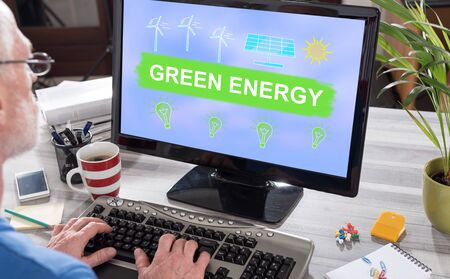 Man using a computer with green energy concept on the screenの写真素材