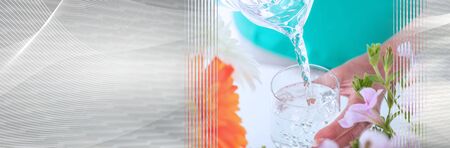 Pouring water from a pitcher into a glass; panoramic bannerの写真素材