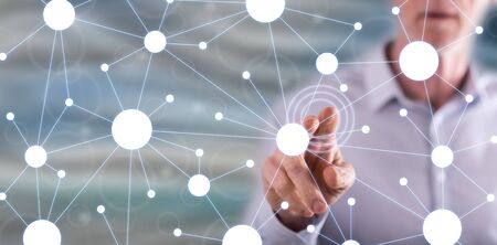 Man touching a virtual network on a touch screen with his fingerの写真素材