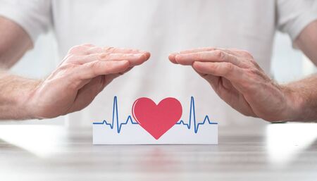 Heartbeat symbol protected by hands - Concept of health insuranceの写真素材