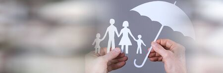 Hand holding an umbrella protecting a family; panoramic banner