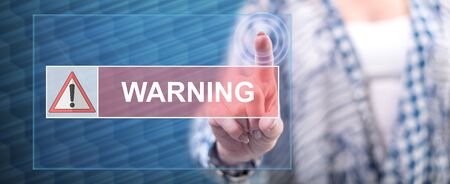 Woman touching a warning concept on a touch screen with her fingerの写真素材