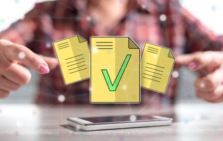 Smartphone with document validation concept between hands of a woman in backgroundの写真素材