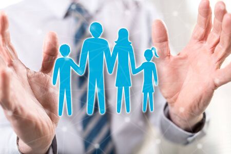 Family concept between hands of a man in backgroundの写真素材