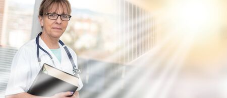 Portrait of female doctor standing and holding a medical textbook; multiple exposureの写真素材