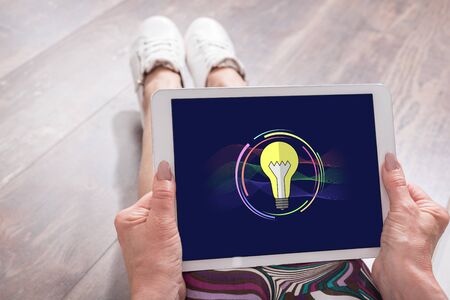 Woman sitting on the floor with a tablet showing innovation concept