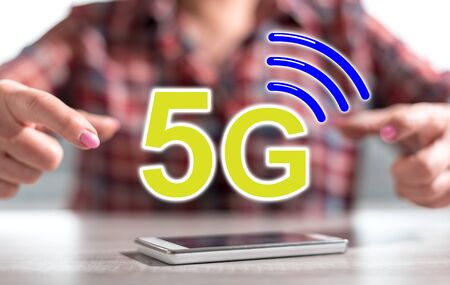 Smartphone with 5g concept between hands of a woman in background