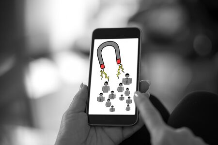 Hand holding a smartphone with customer attraction concept