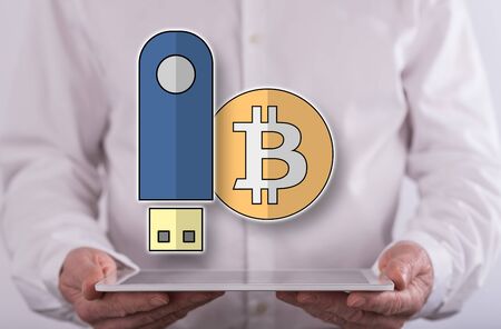 Hardware wallet concept above a tablet held by a man in backgroundの写真素材