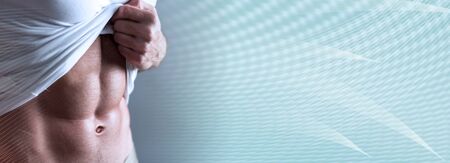 Muscular young man showing abs; panoramic bannerの写真素材