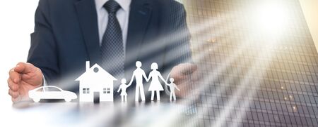 Insurer protecting a family, a house and a car with his hands; multiple exposureの写真素材