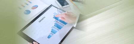 Businesswoman pointing her finger on a graph showing growth; panoramic banner