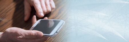 Hand holding a phone, closeup; panoramic banner