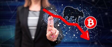 Woman touching a bitcoin bearish trend concept on a touch screen with her fingers