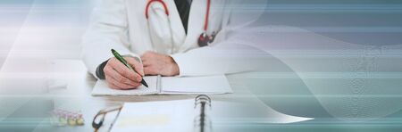 Doctor sitting at desk and taking notes; panoramic bannerの写真素材