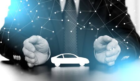 Insurer protecting a car with his hands; multiple exposureの写真素材