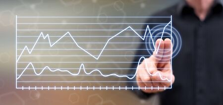 Man touching business charts on a touch screen with his fingers