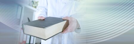 Doctor holding a medical book at office; panoramic bannerの写真素材