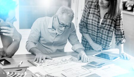 Architects working on plans at office, light effectの写真素材