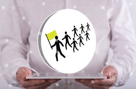 Leadership concept above a tablet held by a man in backgroundの写真素材
