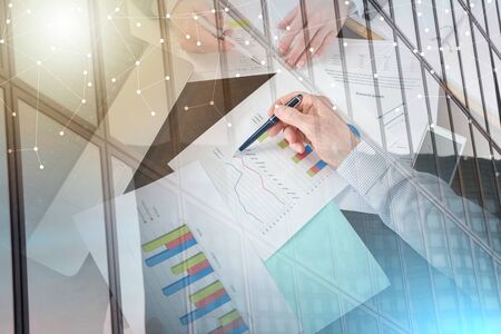 Businesspeople having a discussion about financial report at office; multiple exposure