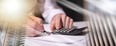 Male hand using calculator, accounting concept; multiple exposure