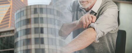 Motivated businessman rolling up his sleeves; panoramic banner; multiple exposureの写真素材
